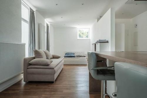 a living room with a couch and a table at Loft mit großer Terrasse bei der Kinderklinik 2C in Siegen