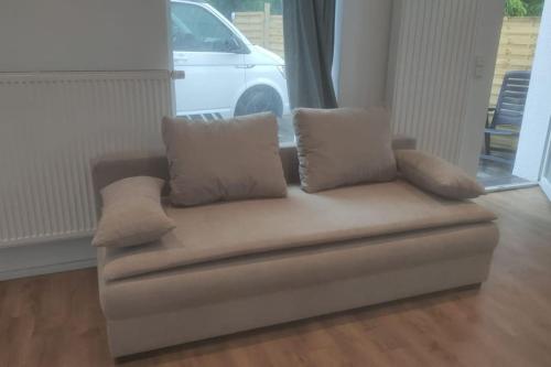 a couch with pillows sitting in a living room at Loft mit großer Terrasse bei der Kinderklinik 2C in Siegen