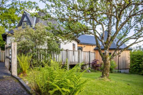 a house with a fence and a tree in the yard at Kinlochlaich Tree House in Appin