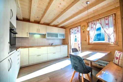 a kitchen with a table and a dining room at Apartments Bea in Ortisei