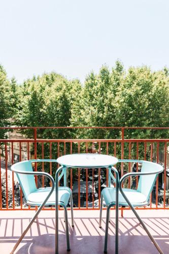 two chairs and a table on a balcony at Hôtel Voltaire in Arles