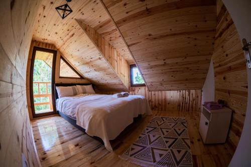 a bedroom in a log cabin with a bed in it at Vilovi Botić in Nova Varoš