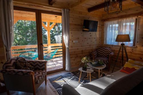 a living room with a couch and chairs and a patio at Vilovi Botić in Nova Varoš