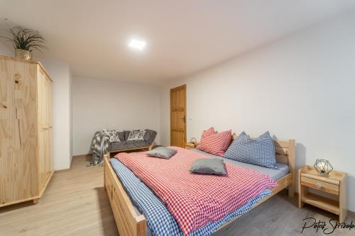 a bedroom with a bed with blue and pink pillows at Roubenka Výletní in Desná