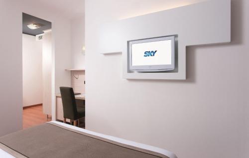 a room with a tv on a wall at Victoria Frontemare Beach & Spa Hotel Jesolo in Lido di Jesolo