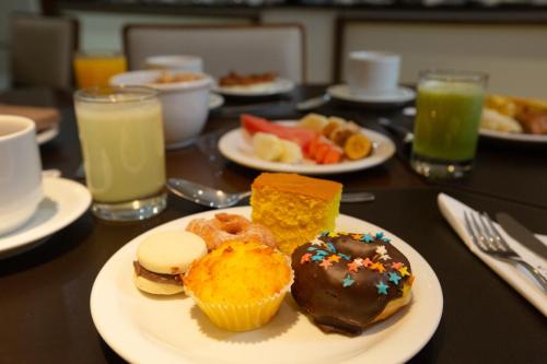 a table topped with plates of pastries and drinks at Viale Tower Hotel in Foz do Iguaçu