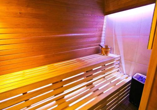 a wooden bench sitting in a room with at Sole Mio Apartment & Wellness in Herceg-Novi