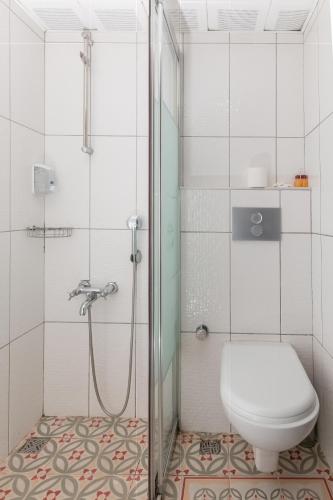 a white bathroom with a shower and a toilet at The Center Hotel in Istanbul