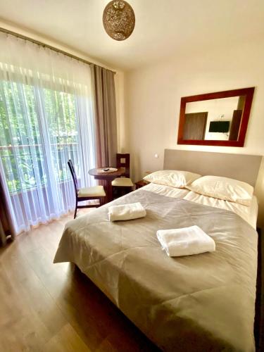 a bedroom with a bed with two towels on it at Gościniec w Zakopanem in Zakopane