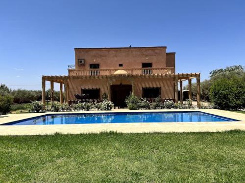 a house with a swimming pool in front of a building at Luxury villa with a pool for your family getaway in Marrakesh