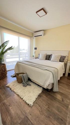 1 dormitorio con 1 cama grande con alfombra en Duplex Champagnat en San Rafael