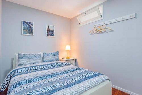 a bedroom with a bed with blue and white sheets at Apartamento Lar doce Lar Porto in Vila Nova de Gaia