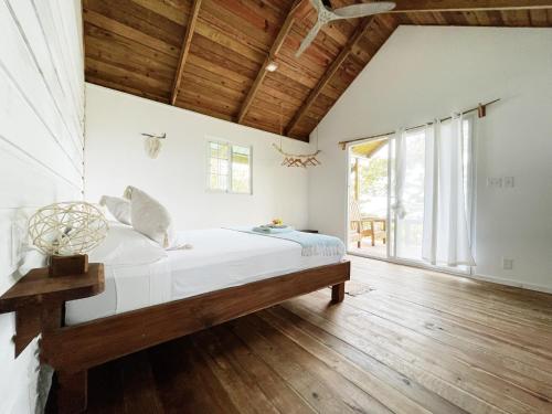 a bedroom with a bed and a wooden floor at Bird Island Bungalows in Bocas del Toro