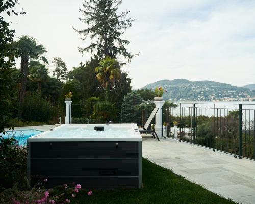 a hot tub on a patio with a view of the water at Hotel Belvedere Ranco in Ranco