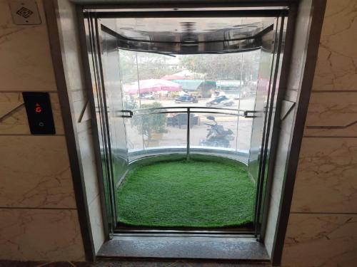 a window with a view of a green yard at Hotel Rose Gold in Ahmadnagar