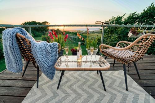 un patio con 2 sillas y una mesa en una terraza en Spacious Sea-View Apt. Overlooking St Ives Bay, en Gwithian