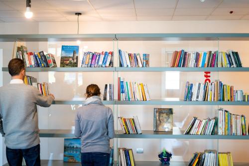 two people are looking at books on shelves at Casa a Colori Padova in Padova
