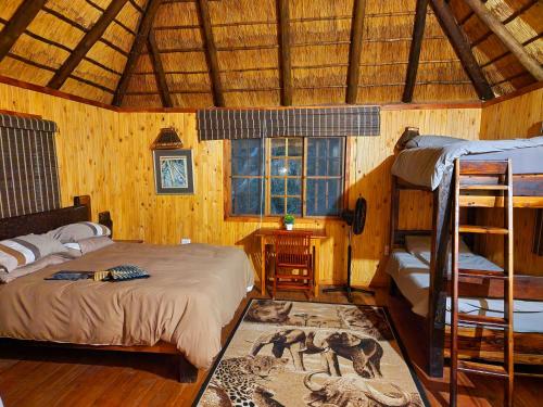 a bedroom with two bunk beds and a desk at Carpe Diem in Marloth Park