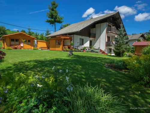 une maison avec une grande cour devant elle dans l'établissement Lookout Resort tiny houses, à Rovte