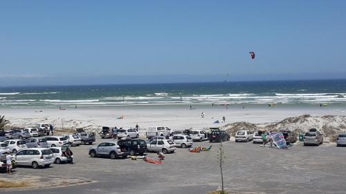 a parking lot with cars parked at the beach at Beach Apartment Melkbosstrand in Melkbosstrand