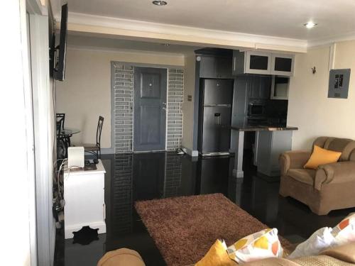 ein Wohnzimmer mit einem Sofa und einer Küche in der Unterkunft 2bed apt with 24hr Security* in Kingston