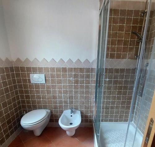 a bathroom with a toilet and a glass shower at Donnigheddu in Rudalza
