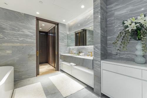 杜拜的住宿－Lavish Sea View 2BR with M at Five Palm，带浴缸、水槽和镜子的浴室