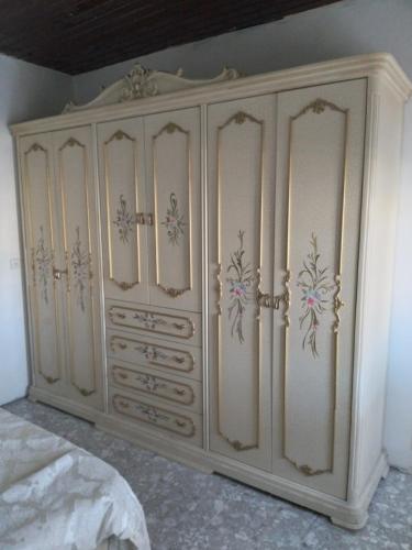 a white cabinet with flowers on it in a bedroom at Moon light in Jerusalem