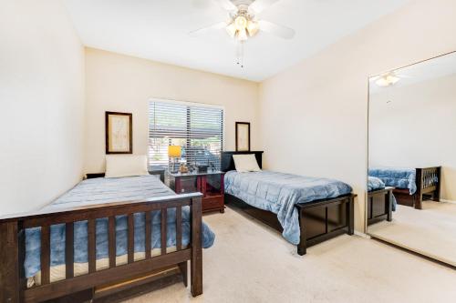 a bedroom with two beds and a mirror at Desert Breeze Villas #137 in Phoenix
