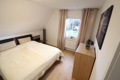 een kleine slaapkamer met een bed en een raam bij Nordsand in Cuxhaven