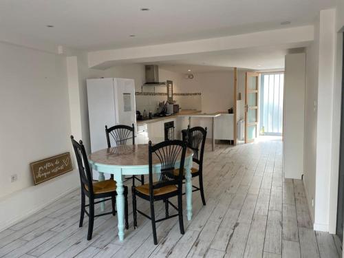 une cuisine et une salle à manger avec une table et des chaises dans l'établissement Charentaise 6-8 personnes avec piscine, à Tonnay-Charente