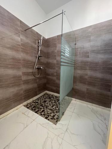 W łazience znajduje się prysznic ze szklanymi drzwiami. w obiekcie Magnifique villa avec piscine sur l’île de djerba w mieście Houmt Souk