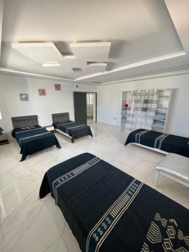 um quarto grande com três camas em Magnifique villa avec piscine sur l’île de djerba em Houmt Souk