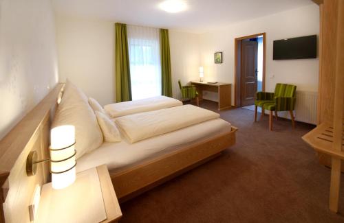 a hotel room with a bed and a desk at Lauras Landhauspension in Medebach