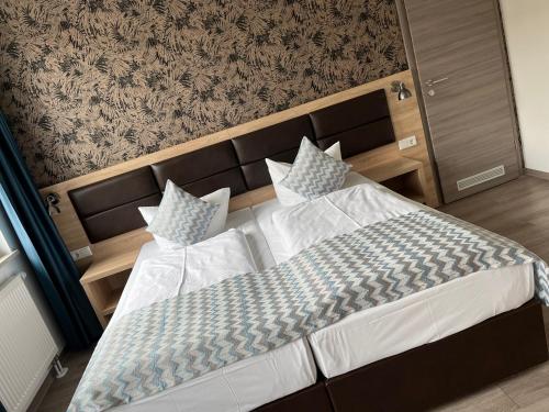 een slaapkamer met een groot bed met een hoofdeinde en kussens bij Hotel LACIN in Neurenberg