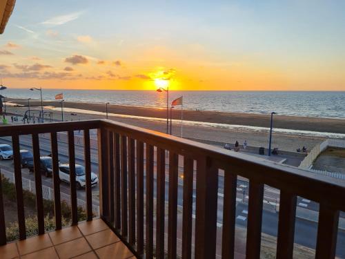 a view of the beach at sunset from a balcony at Cote et Mer Superbe appartement Front de Mer WIFI & PARKING in Villers-sur-Mer