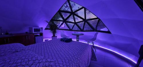 um quarto com um quarto roxo com uma cama em Glamping Gaia Origen en Cali - Cabaña y Domo Geodésico a 10 min de los Gatos del Río em Cali