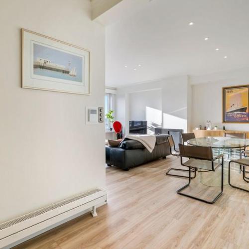 a living room with a table and a couch at Unique Seaview close to Casino - garage available - "Monte Carlo" in Ostend
