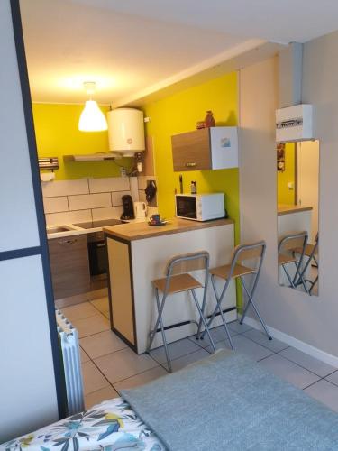 - une cuisine avec 2 chaises et un comptoir dans une pièce dans l'établissement Agréable studio dans le centre historique, à La Ferté-Saint-Aubin