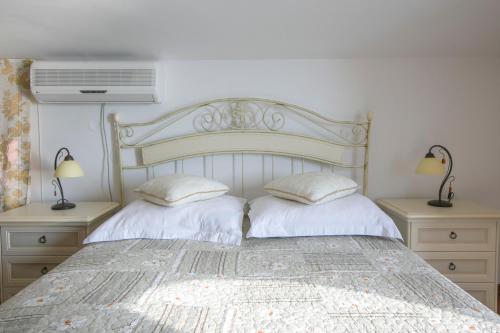 a bedroom with a large bed with two pillows at Royal Holiday Apartments Sveti Stefan in Sveti Stefan