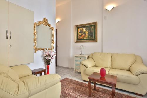 a living room with two couches and a mirror at Royal Holiday Apartments Sveti Stefan in Sveti Stefan