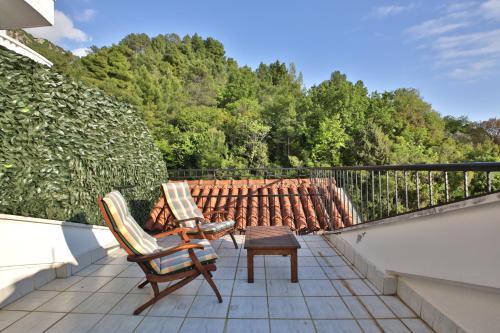 a patio with two chairs and a table on a balcony at Royal Holiday Apartments Sveti Stefan in Sveti Stefan