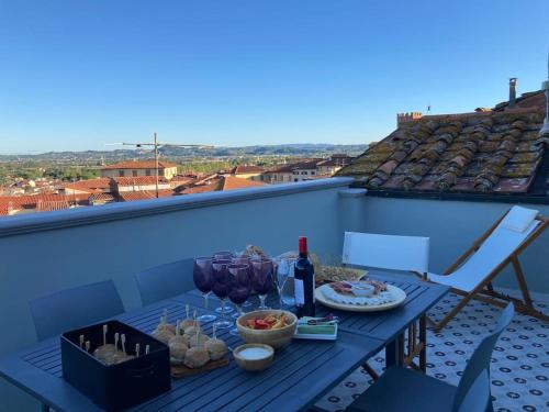 einen Tisch mit Essen und Weingläsern auf dem Balkon in der Unterkunft Castruccio 4 - casa con vista sulla via Francigena in Fucecchio