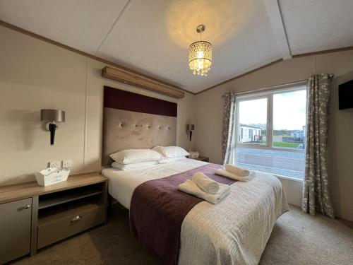 a bedroom with a large bed and a window at Stewarts Resort Lodge 31 in St Andrews