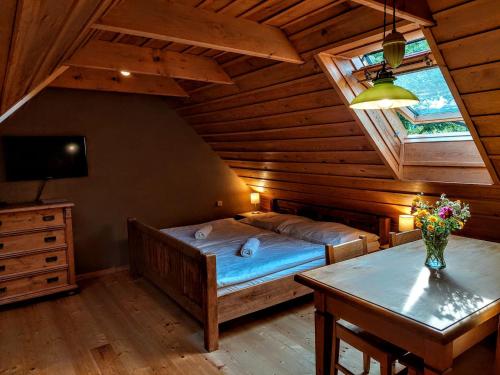 a bedroom with a bed and a table in a attic at Apartmány Červený Dvůr in Chvalšiny