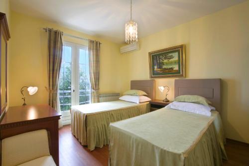 a room with two beds and a window at Royal Holiday Apartments Sveti Stefan in Sveti Stefan