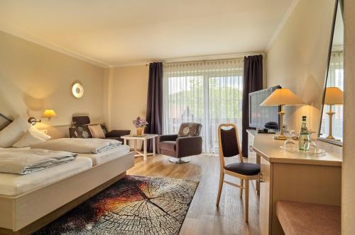 a hotel room with a bed and a desk at Das Reiners in Grafenau