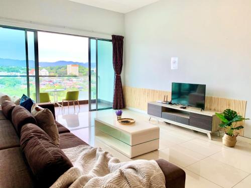 a living room with a couch and a flat screen tv at Deco Home @ Imago The Loft in Kota Kinabalu