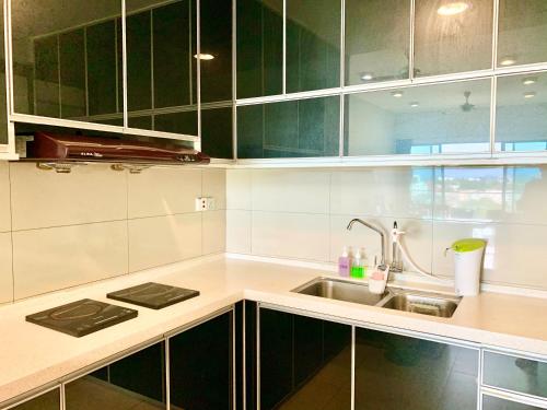 a kitchen with green cabinets and a sink at Deco Home @ Imago The Loft in Kota Kinabalu
