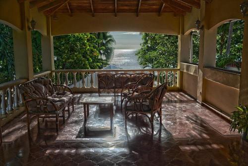 a porch with chairs and a table on a balcony at Hotel El Velero in Playa Hermosa